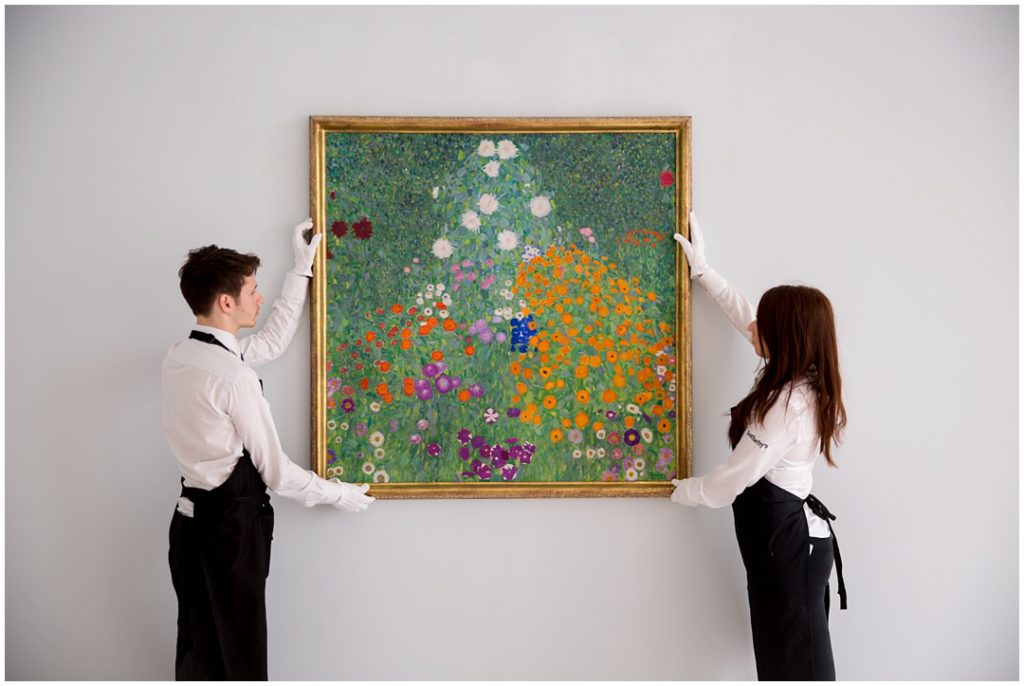 Sotheby's art handlers holding Klimt painting