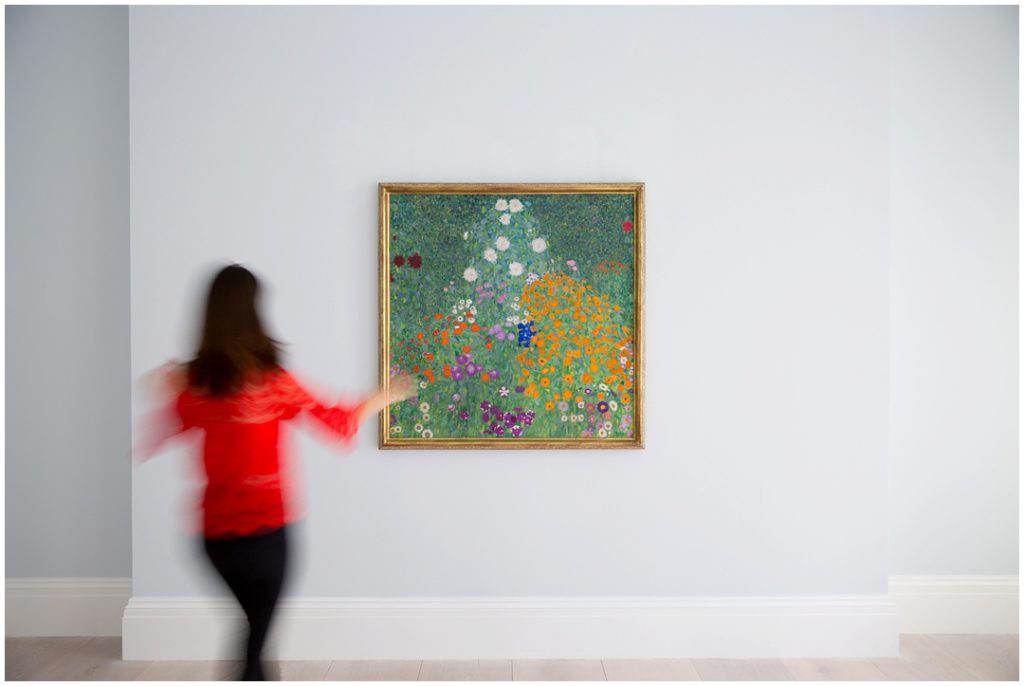 Modern photo of woman in red and Klimt painting at Sotheby's in London