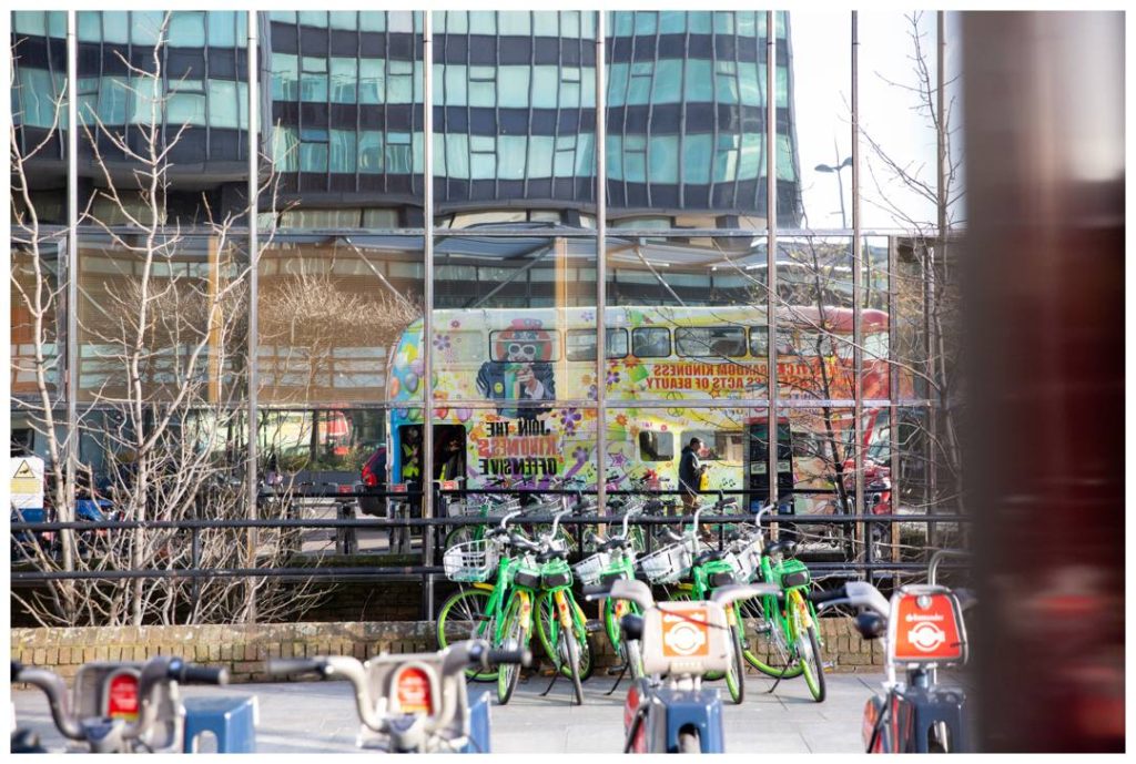 Reportage Charity event photography in London with reflection of the Kindness Offensive bus in Euston