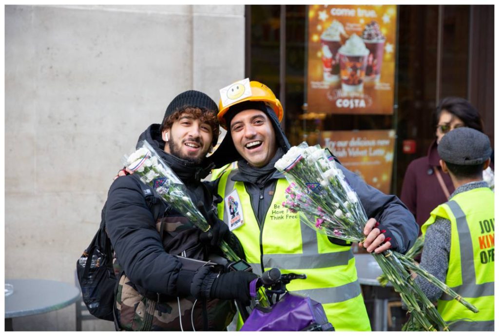 London event photo capturing Cyclist and Kindness Offensive volunteer with their flowers