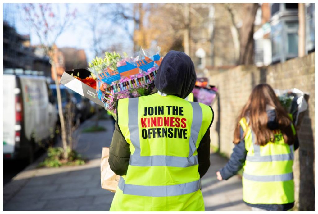 Volunteers carrying flowers captured by Nicola Bushnell from tribal London Event Photography