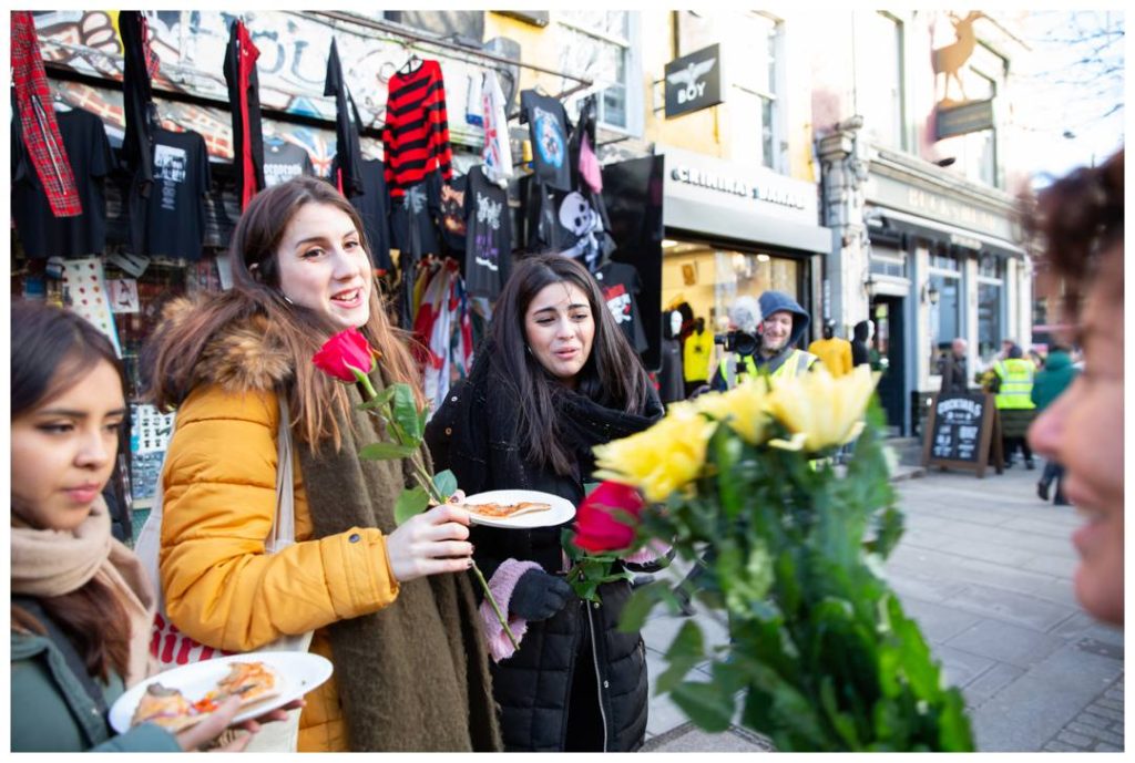 Ruby Wax giving flowers to women in Camden