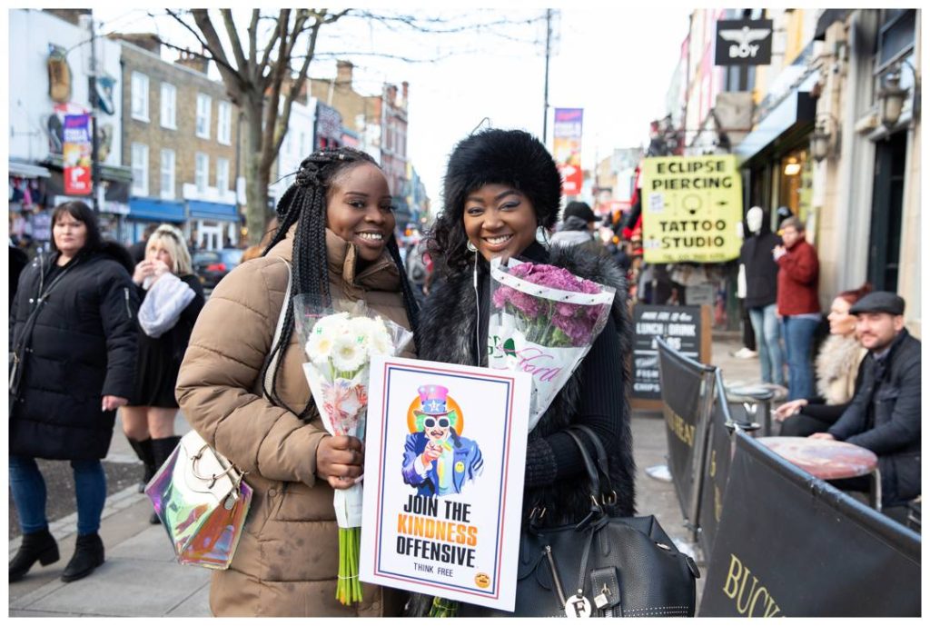 Two young women in Camden high street holding their flowers