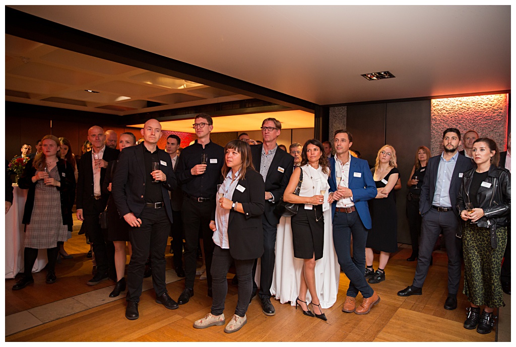 Wide shot of guests listening to a welcome speech at Barbican exhibition launch