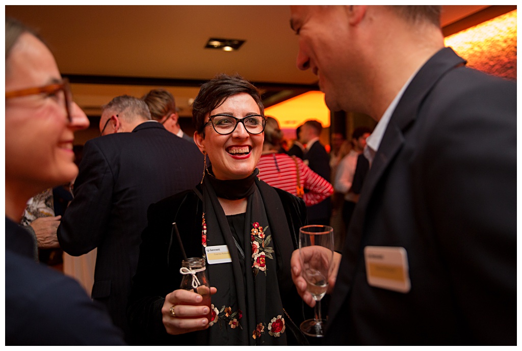 Guests drinking and laughing in the Garden Room at the Barbican events space